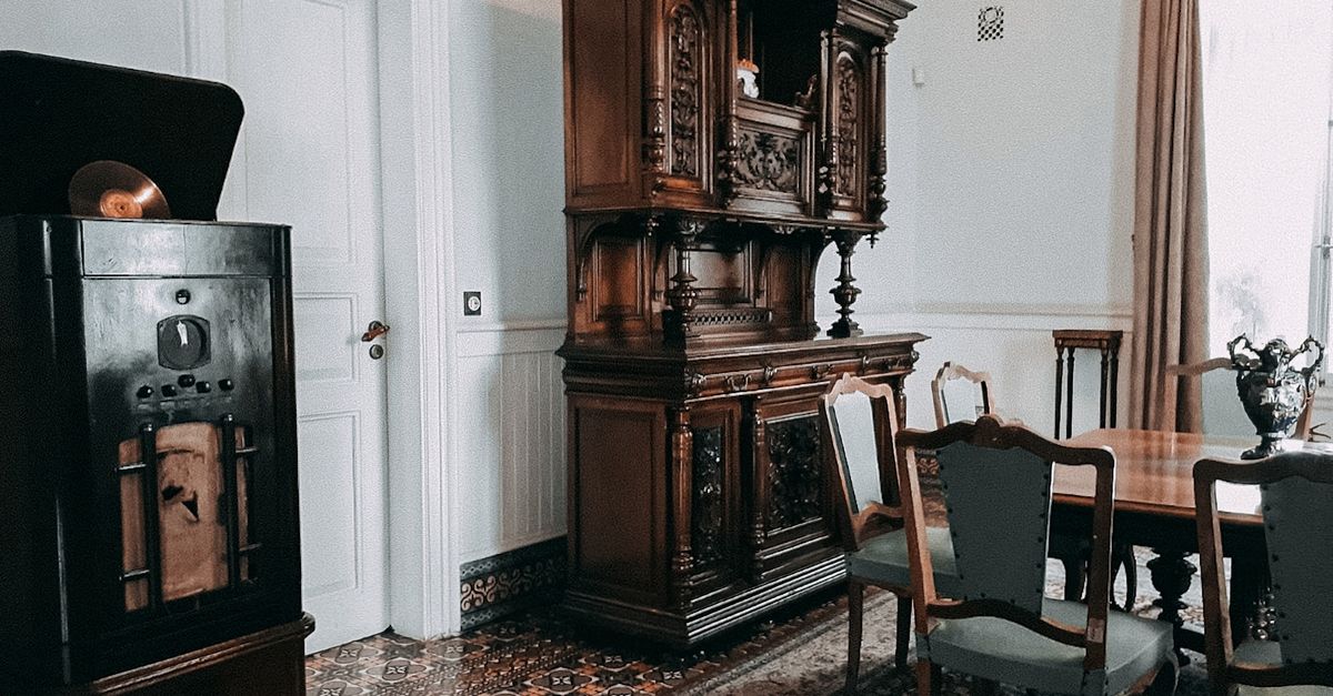 Vintage dining room interior featuring an ornate wood cabinet and gramophone with antique decor.